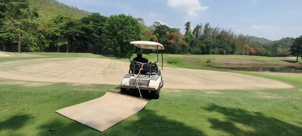 Alpinegolfresort Chiangmai 1 person golfing golf cart and golf course