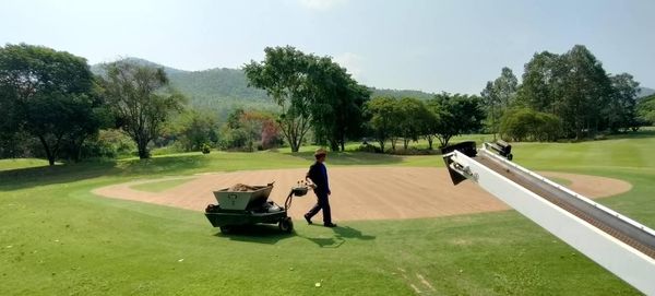 Alpinegolfresort Chiangmai 1 person golfing golf cart grass and golf course-5
