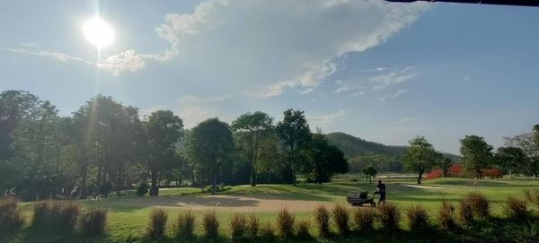 Alpinegolfresort Chiangmai 2 people golf cart golf course and grass
